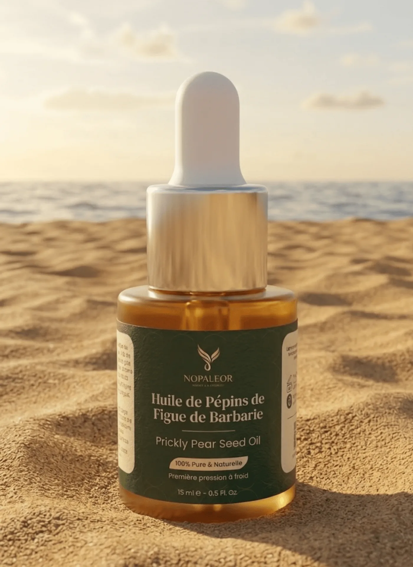 Le flacon de 15 ml posé sur le sable, à contre-jour